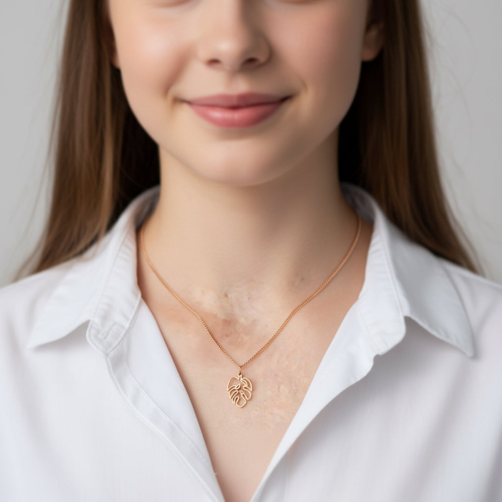 gold monstera charm on curb chain on model