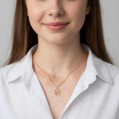 gold monstera charm on curb chain on model