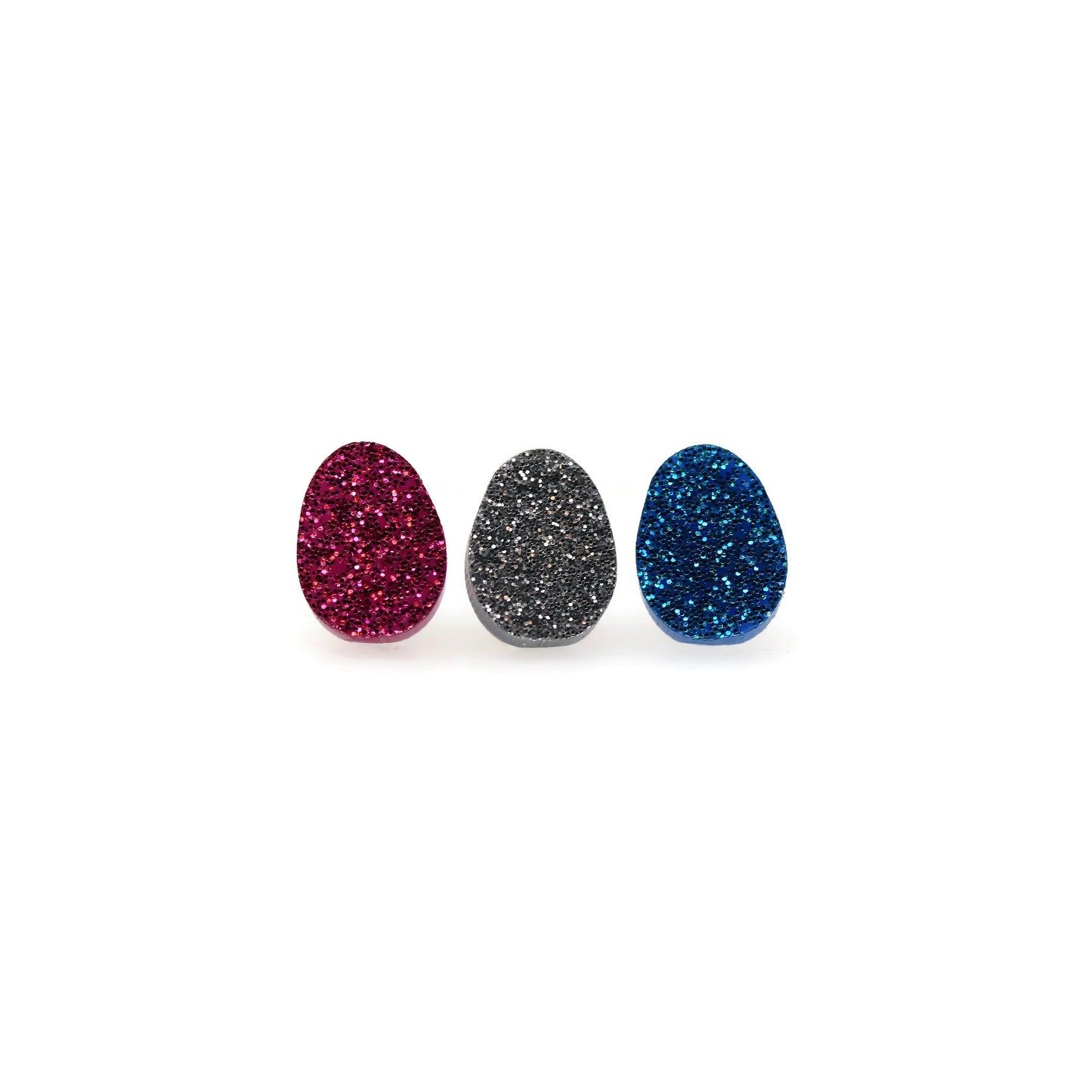 Three glittery Easter egg-shaped stud earrings in red, gray, and blue, displayed side by side against a white background.