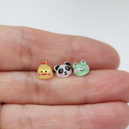 chicken, panda and frog earring in hand