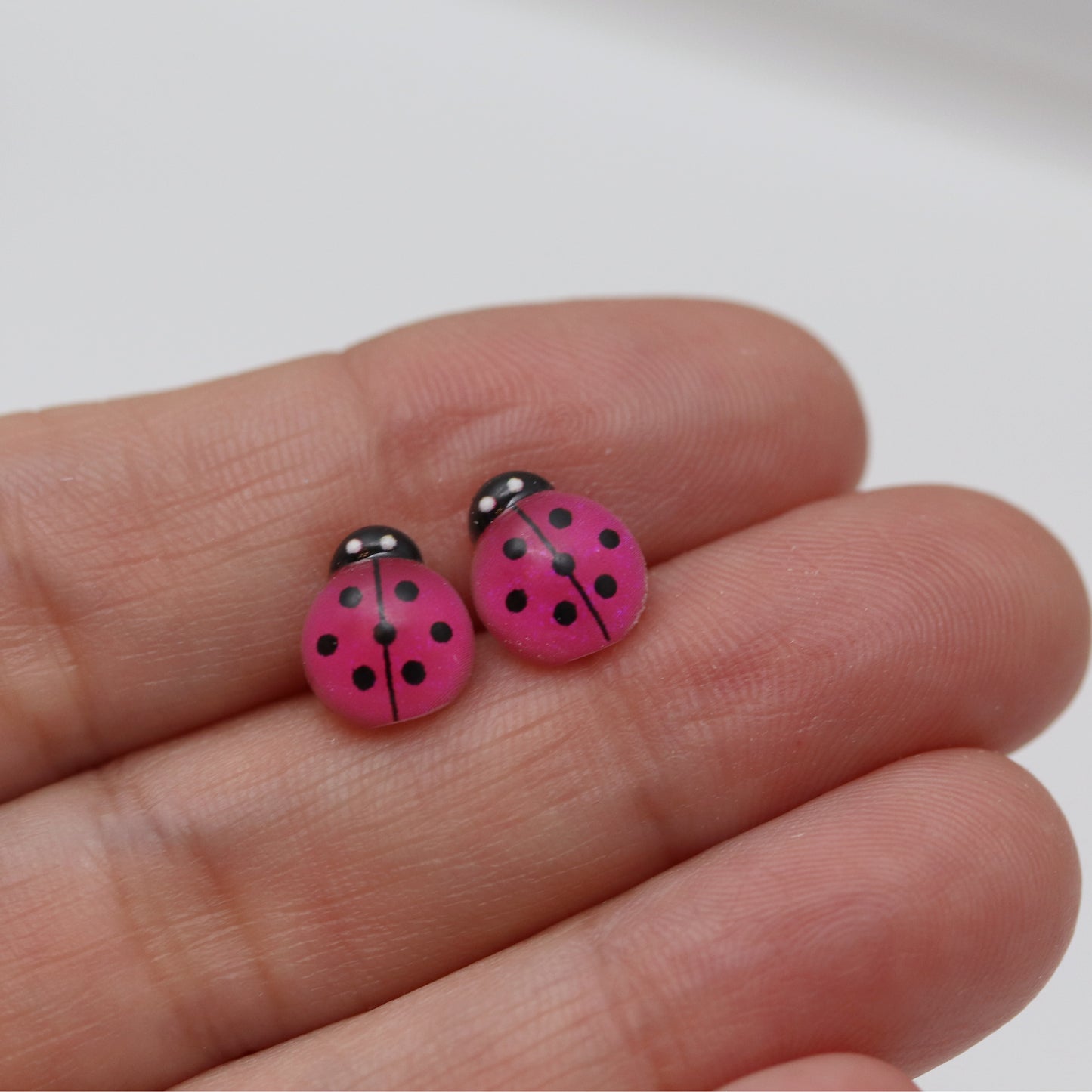 pink ladybug earrings in hand