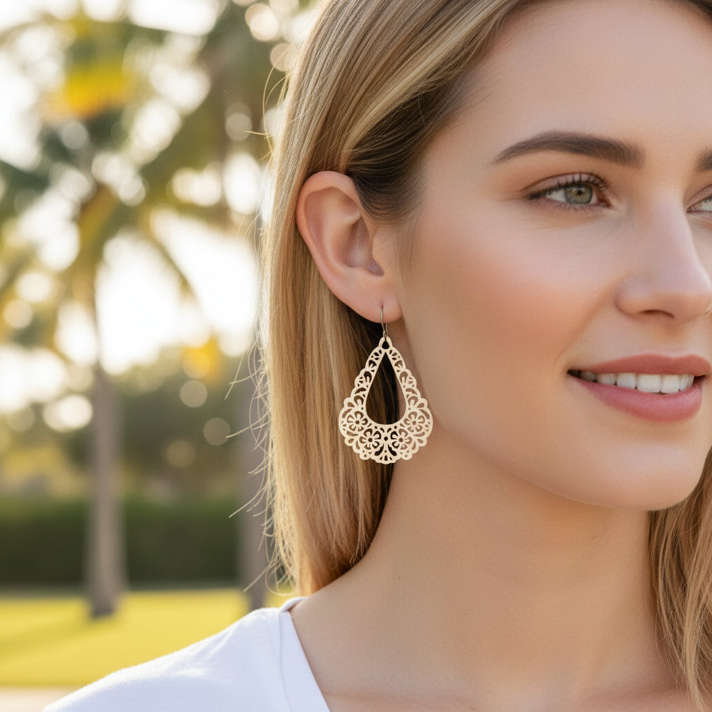 gold floral dangle earrings in ear