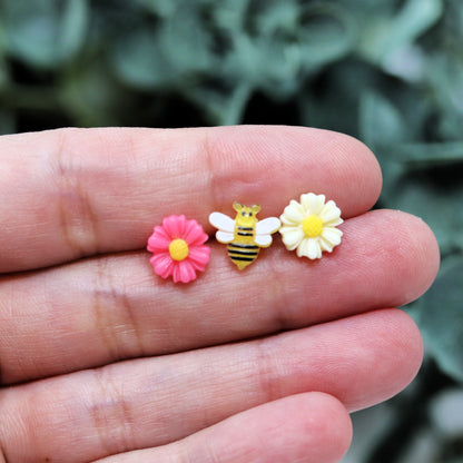 pink and white daisy, bee earrings set of three in a hand