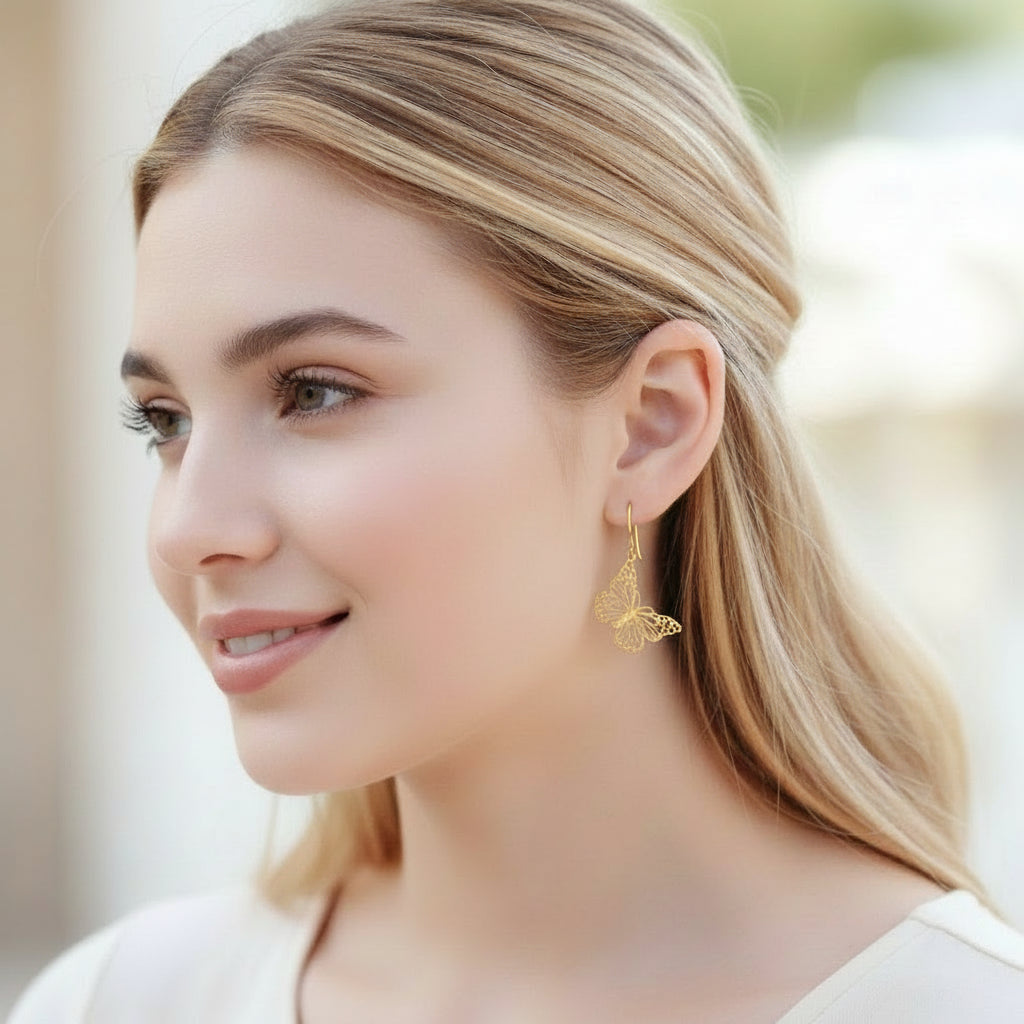 Woman wearing butterfly earrings with a blurred background