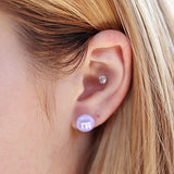 purple m&m earring in an ear