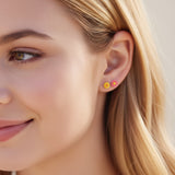 6mm yellow flower and pink flower earrings in an ear