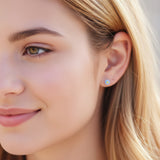 6mm blue flower earring in an ear