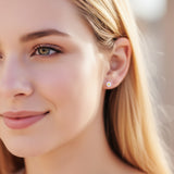 white 6mm flower earring in an ear