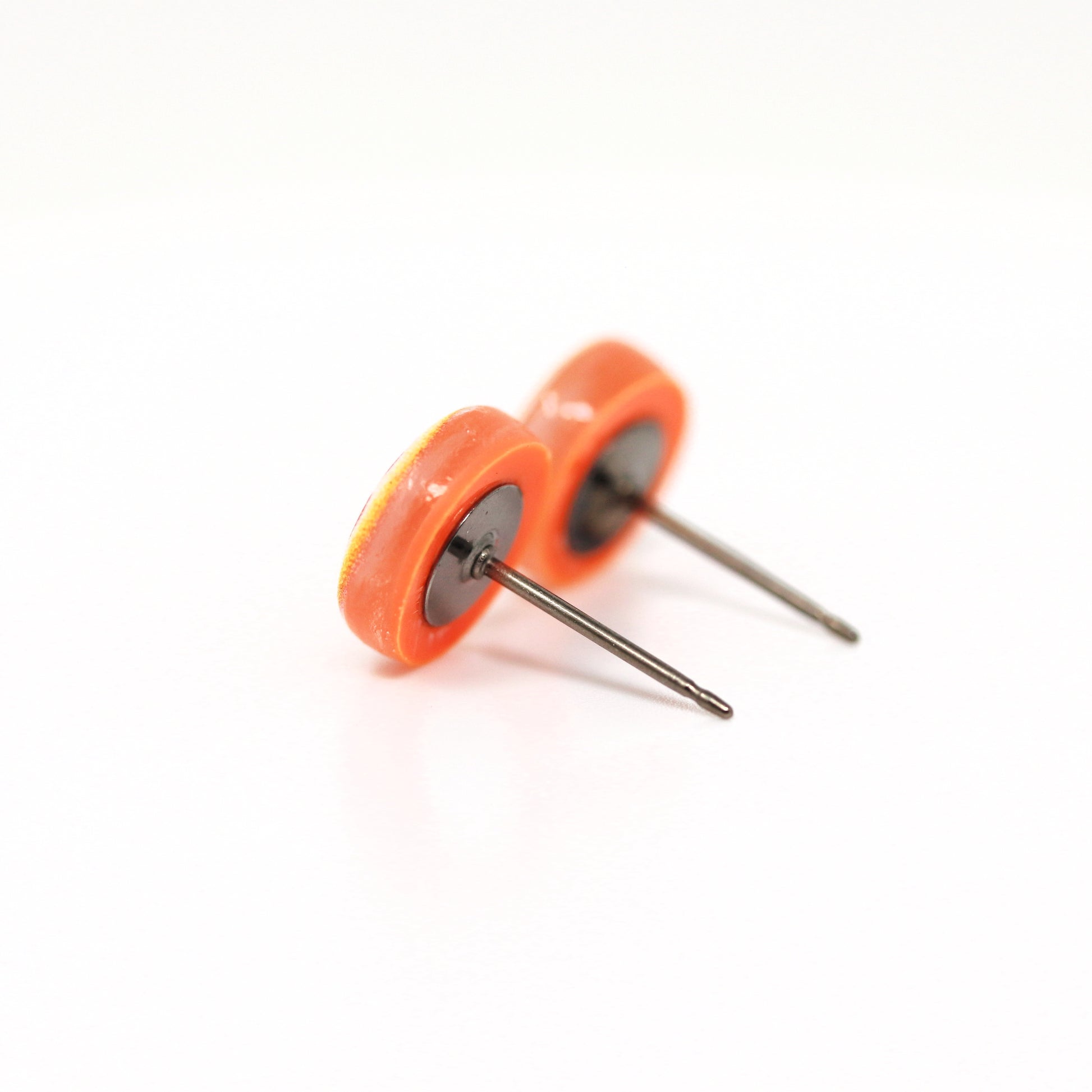 orange earrings on titanium posts