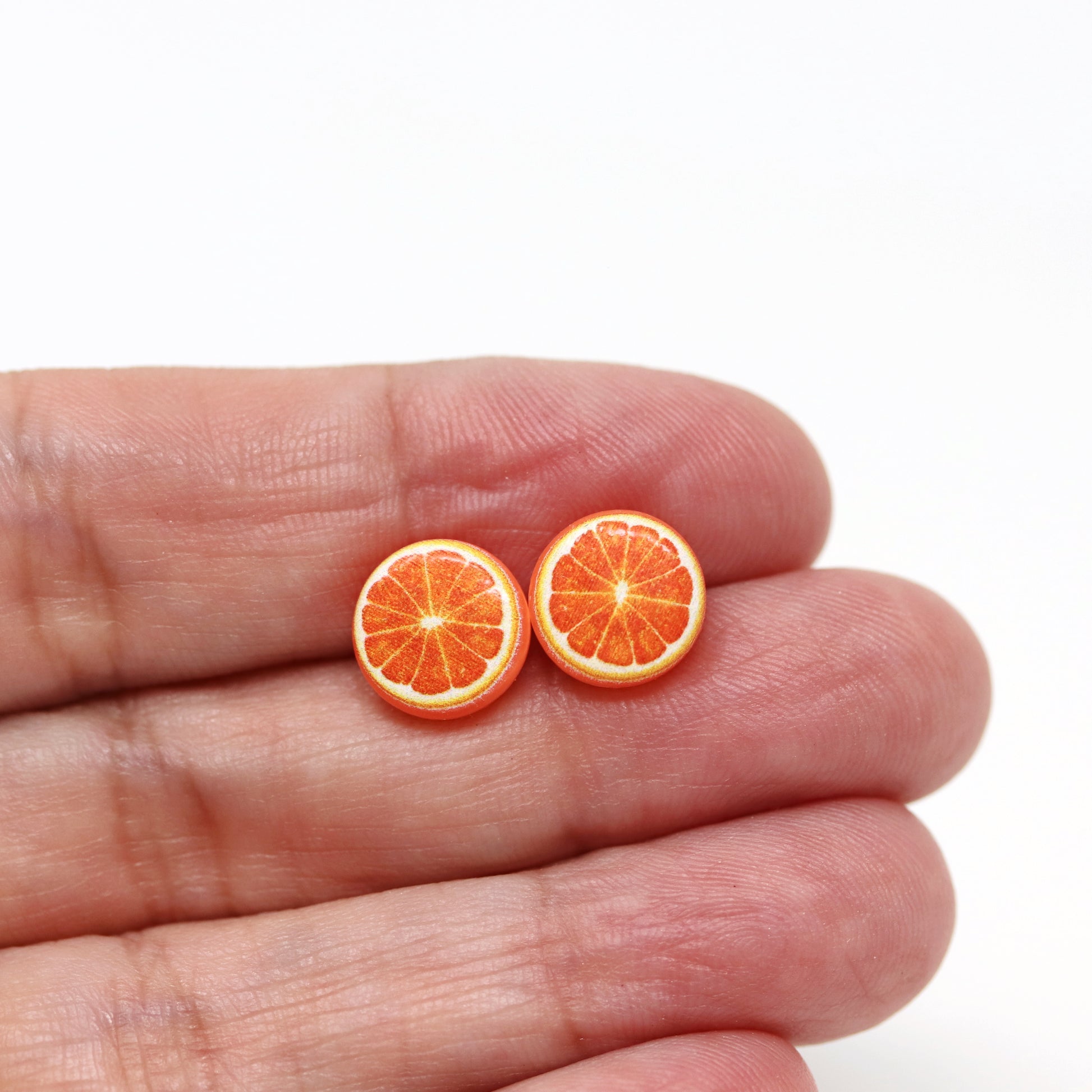 orange earrings in a hand