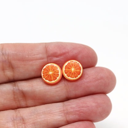 orange earrings in a hand