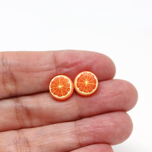 orange earrings in a hand
