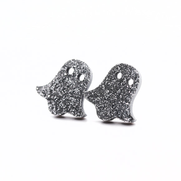 Ghost-shaped earrings with glittery texture on a white background