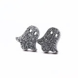 Ghost-shaped earrings with glittery texture on a white background