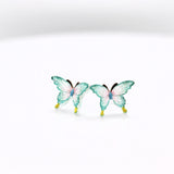 Two aqua butterfly figurines on a white background