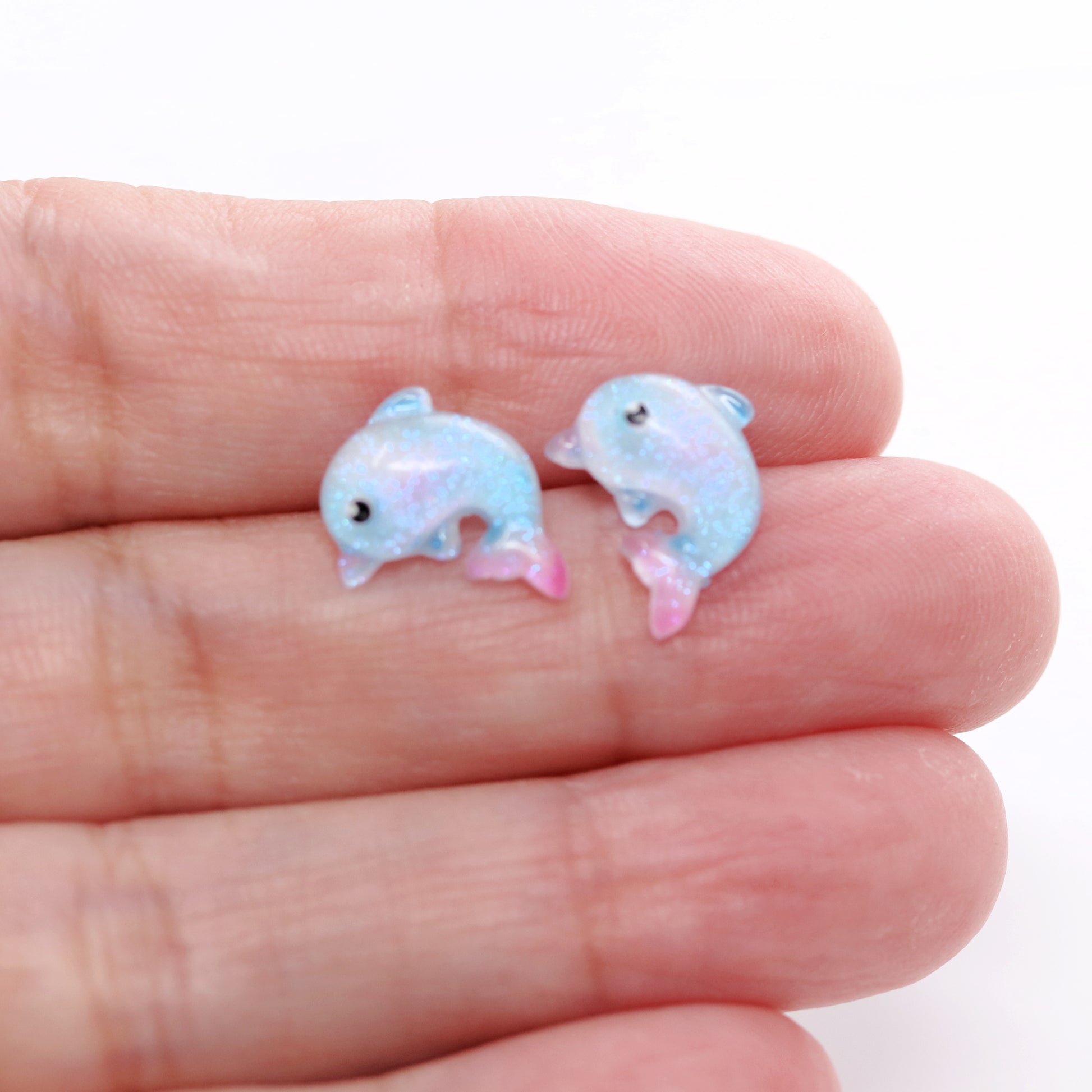 dolphin earrings in a hand