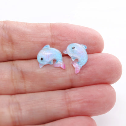 dolphin earrings in a hand