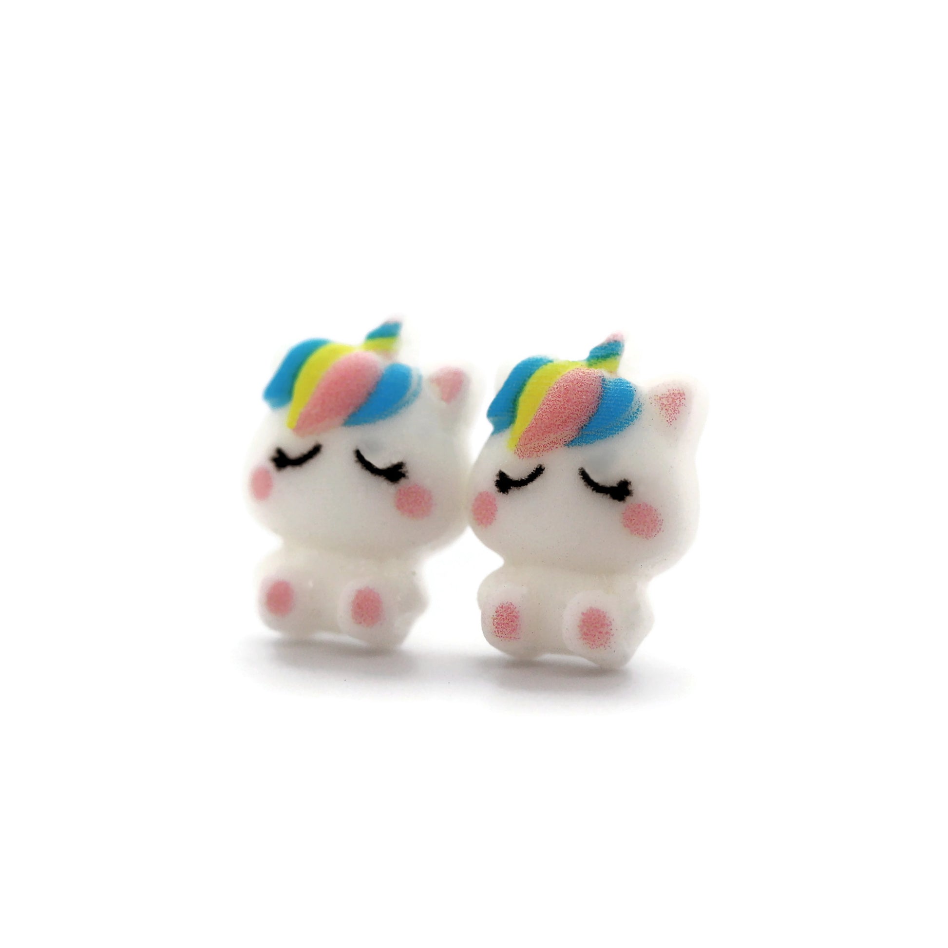 A pair of white unicorn stud earrings with rainbow-colored manes, crafted from resin, displayed against a white background.