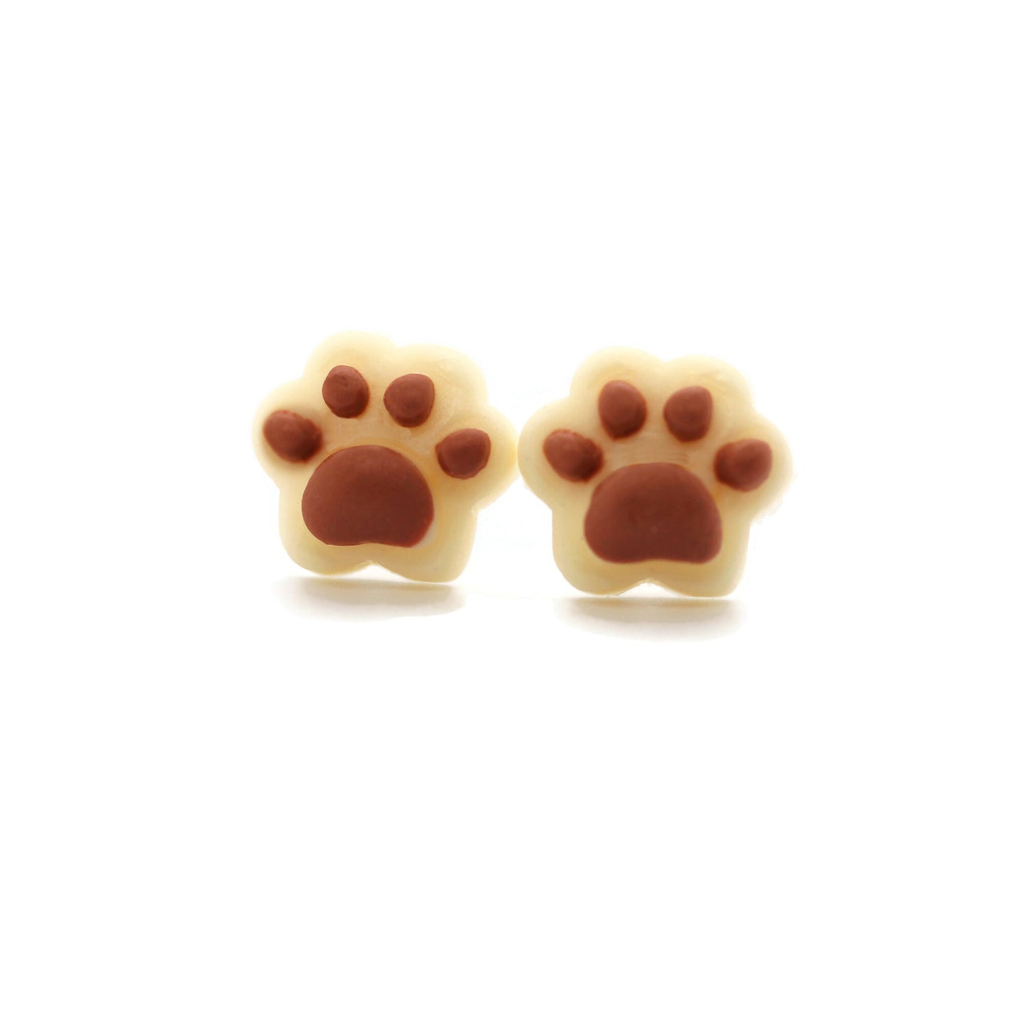 A pair of dainty paw print-shaped stud earrings in a beige color with brown details on a white background.