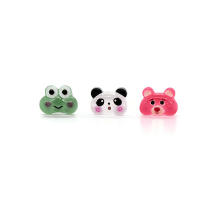 A set of three stud earrings featuring a green frog, white panda, and pink bear designed with resin material.