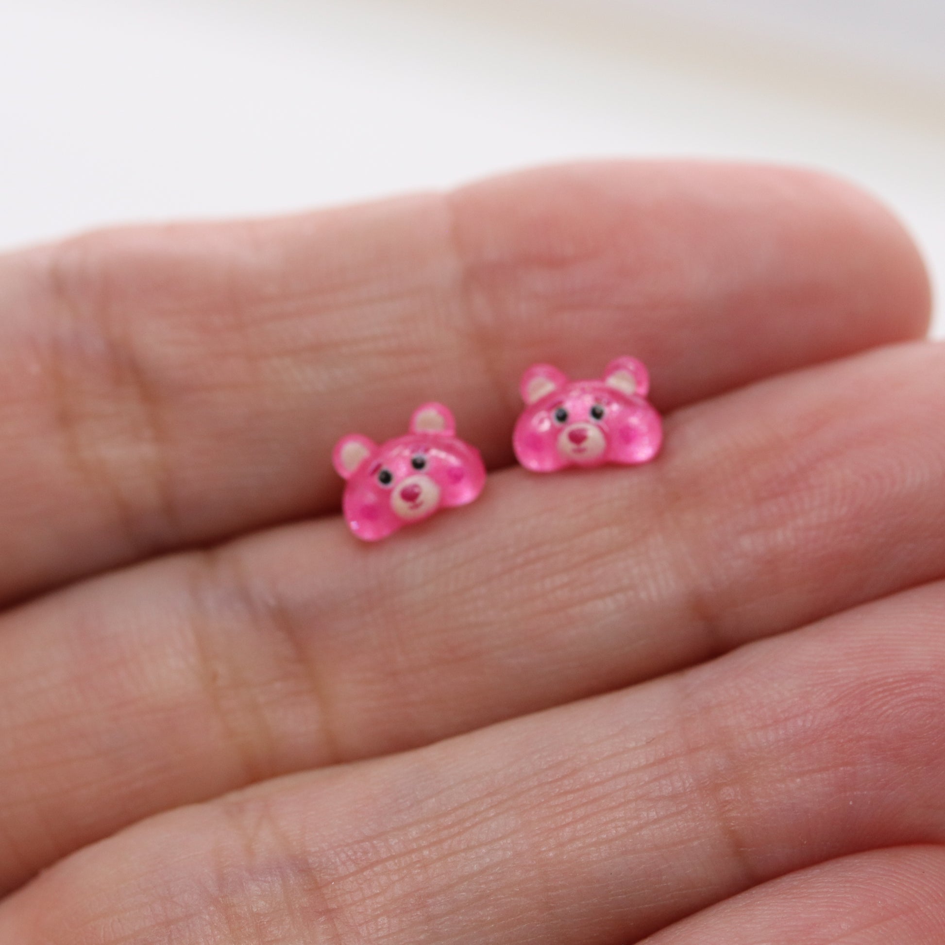 pink bear earrings in a hand