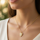 Gold leaf pendant necklace on a white background