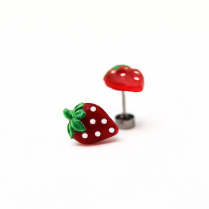 A pair of red strawberry-shaped stud earrings with green accents and white dots on a white background.