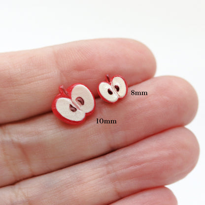 apple stud earrings in a hand