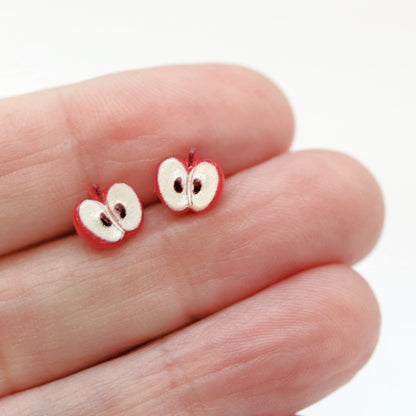 apple stud earrings in a hand