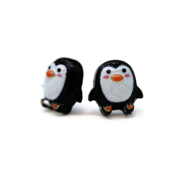 Pair of black and white penguin-shaped earrings on a white background