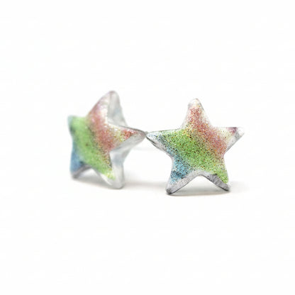 A pair of multicolor glitter star-shaped stud earrings on a white background.