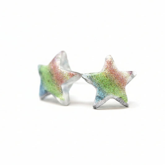 A pair of multicolor glitter star-shaped stud earrings on a white background.