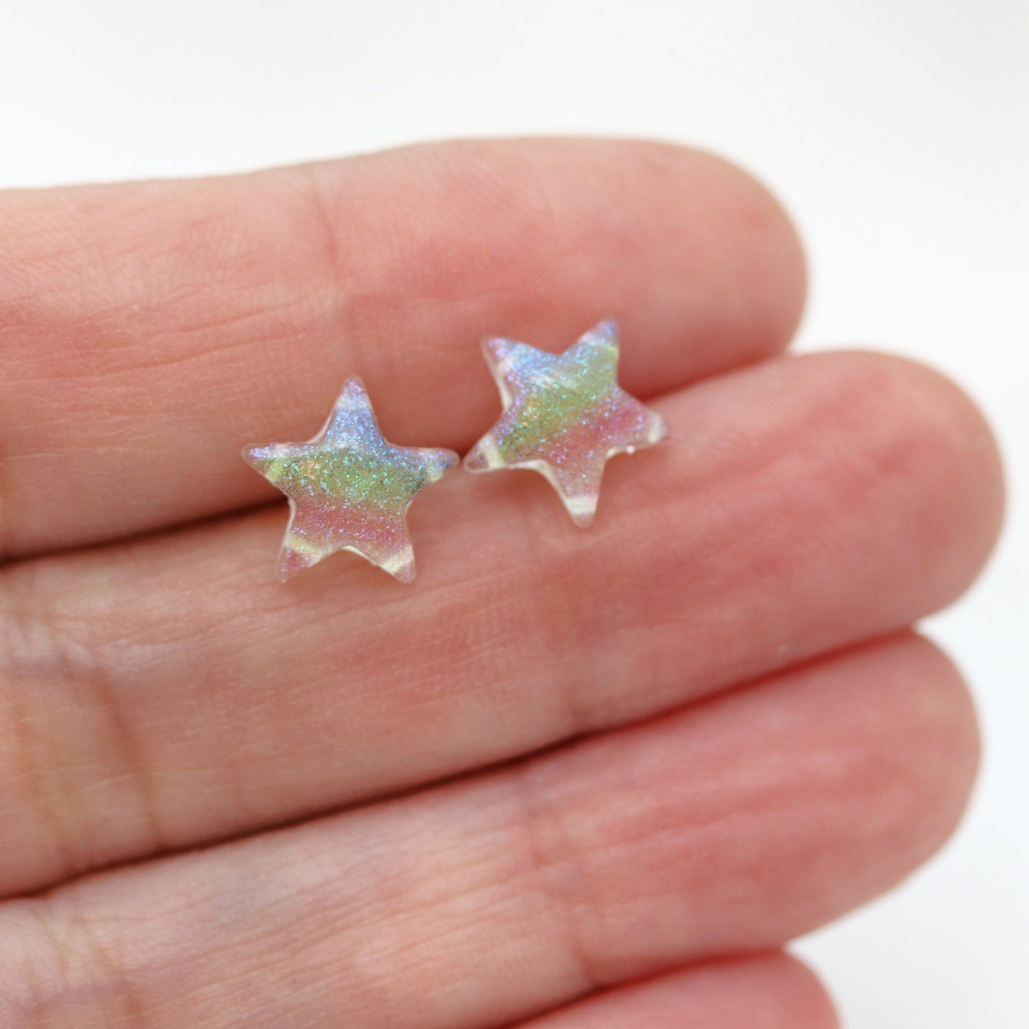 multi color glitter star earrings in a hand