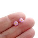 purple 6mm flower earring in a hand