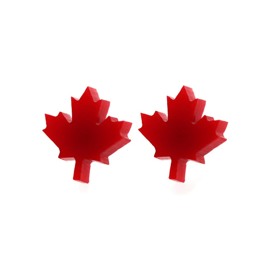 A pair of red maple leaf-shaped stud earrings against a white background.