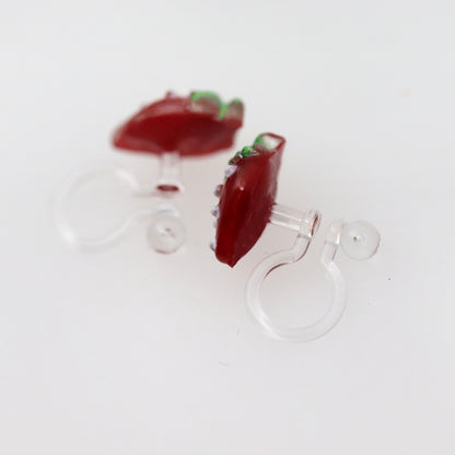 A pair of red strawberry-shaped stud earrings with green accents and white dots on a white background.