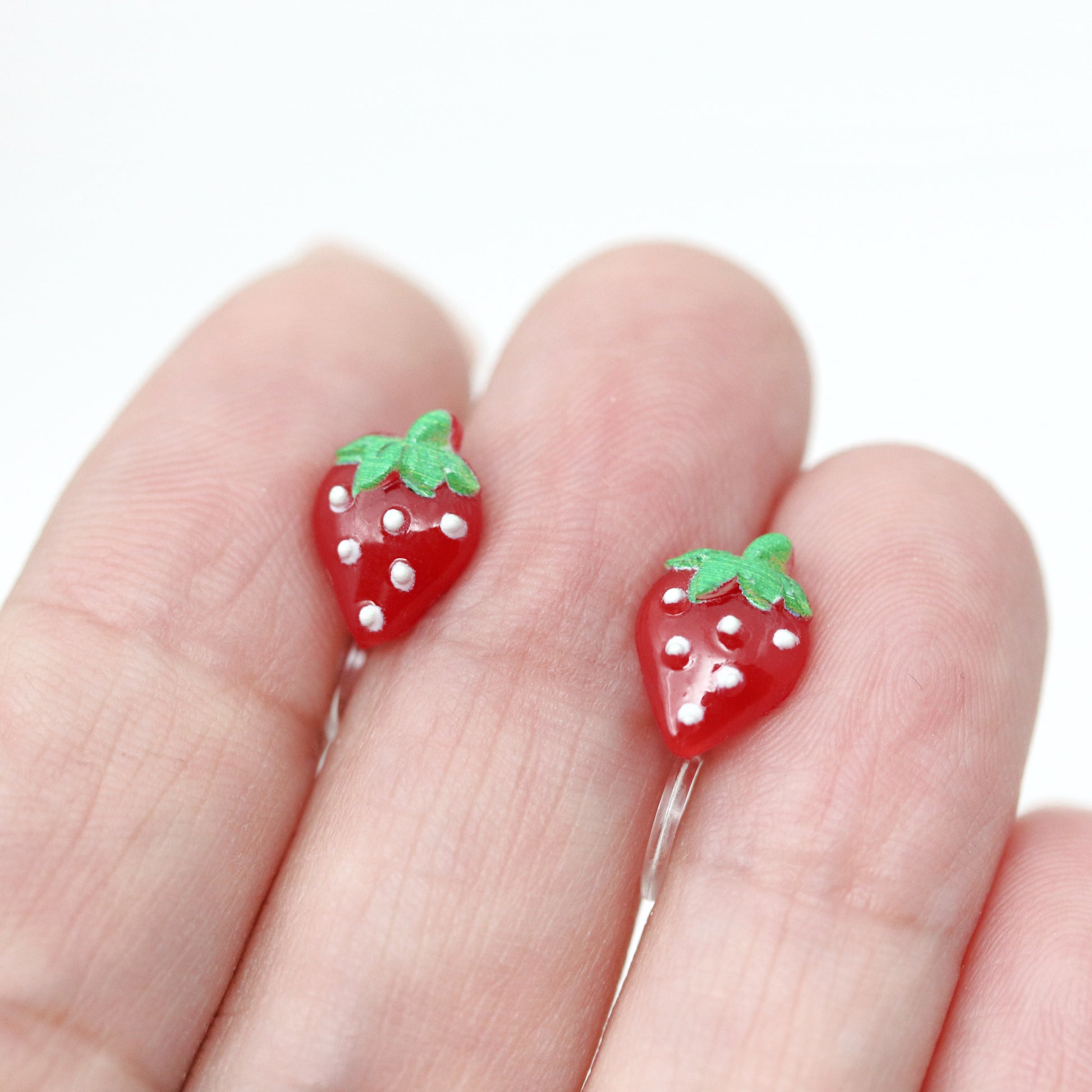 strawberry earrings in someones hand