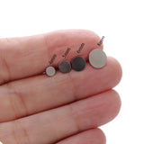 Four glue pads of different sizes held between fingers on a white background