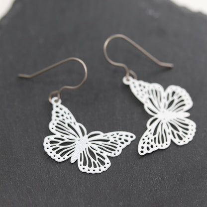 Butterfly-shaped earrings on a dark surface