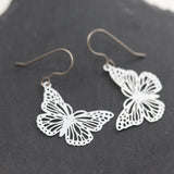 Butterfly-shaped earrings on a dark surface