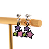 Colorful star-shaped earrings on a wooden stand against a white background