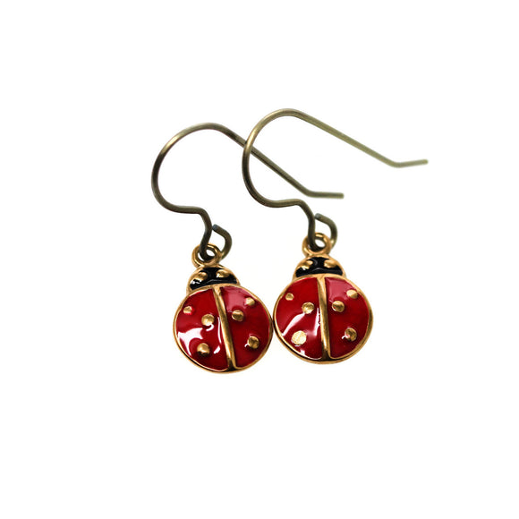 Red ladybug earrings with gold accents on a white background