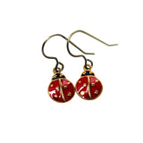 Red ladybug earrings with gold accents on a white background