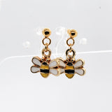 Gold bee-shaped earrings on a white background