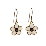 White flower-shaped earrings with black centers on a white background