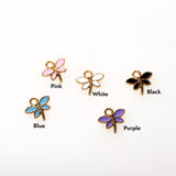 Set of dragonfly-shaped charms in various colors on a white background