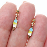 Ice cream cone-shaped earrings on a hand with a white background