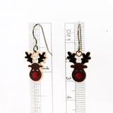 Reindeer-shaped earrings with a ruler for scale on a white background