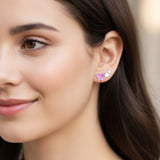 Close-up of an ear wearing pink and purple butterfly earrings with text indicating color and style.