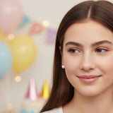 Close-up of an ear with cupcake earrings against a blurred background